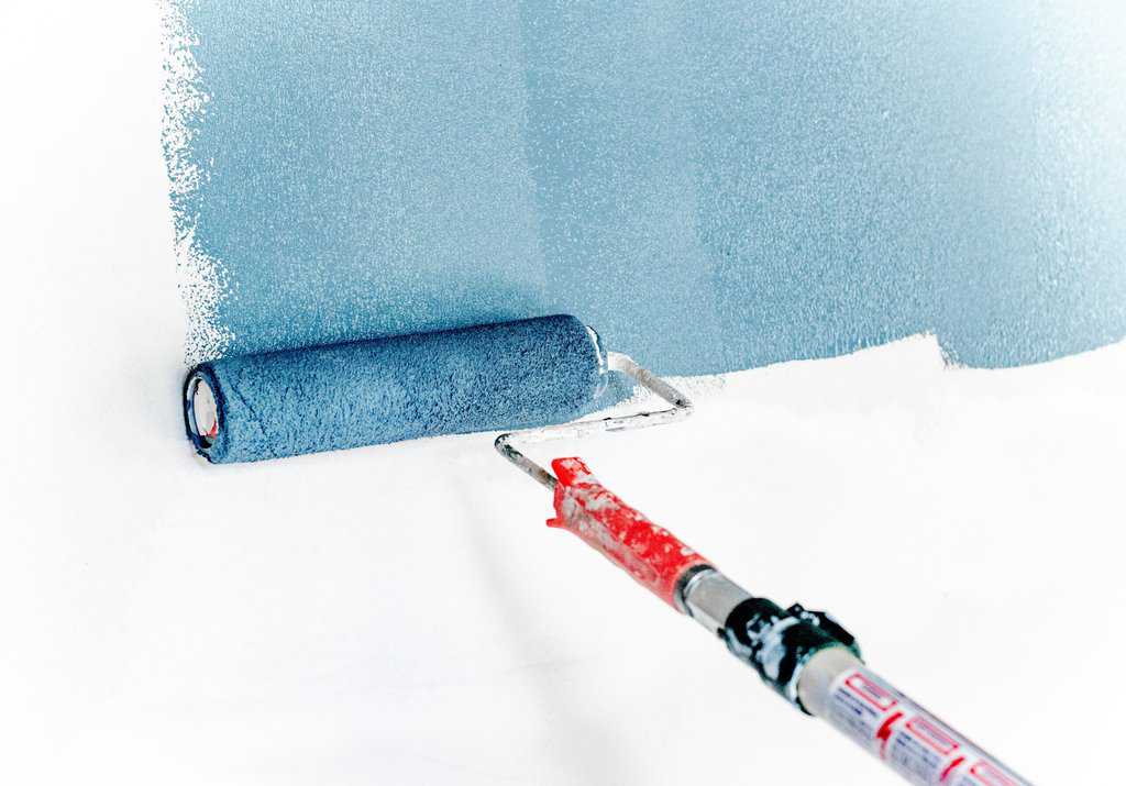 a paint roller is being used to paint a blue wall.
