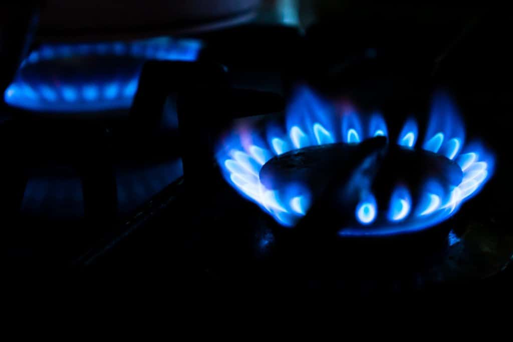 a gas stove with blue flames in the dark.