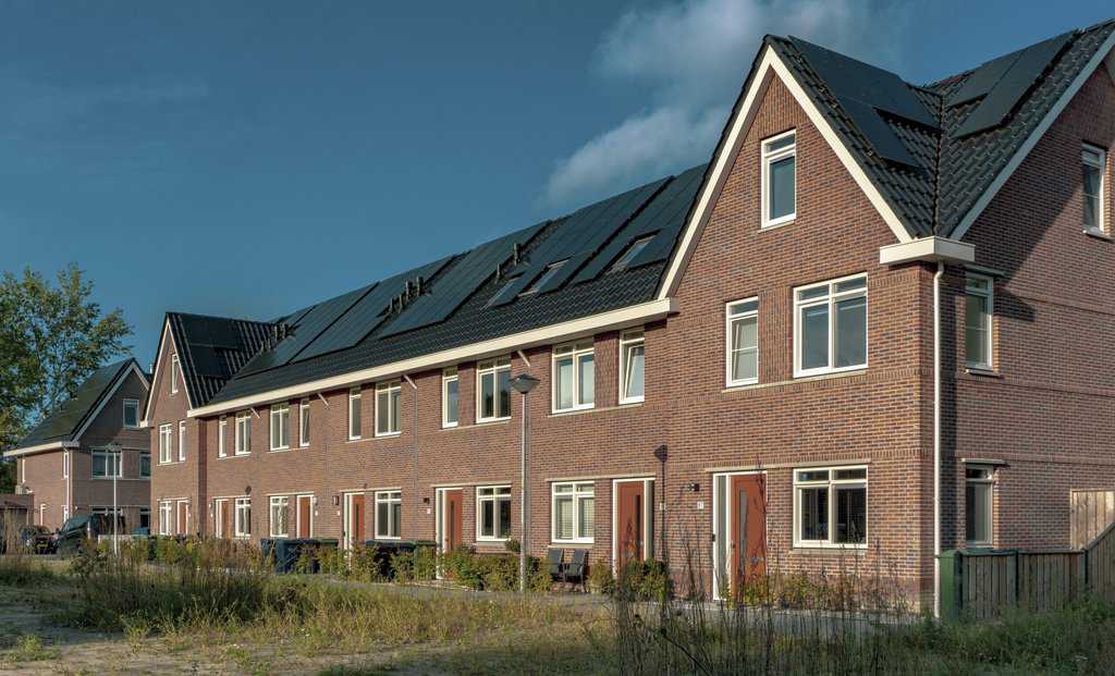 a row of houses with solar panels on their roofs.
