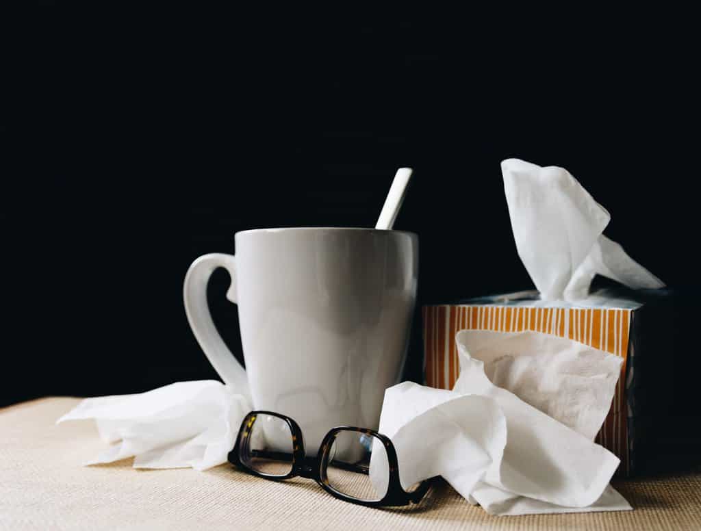 a cup of coffee, tissue and glasses on a table.