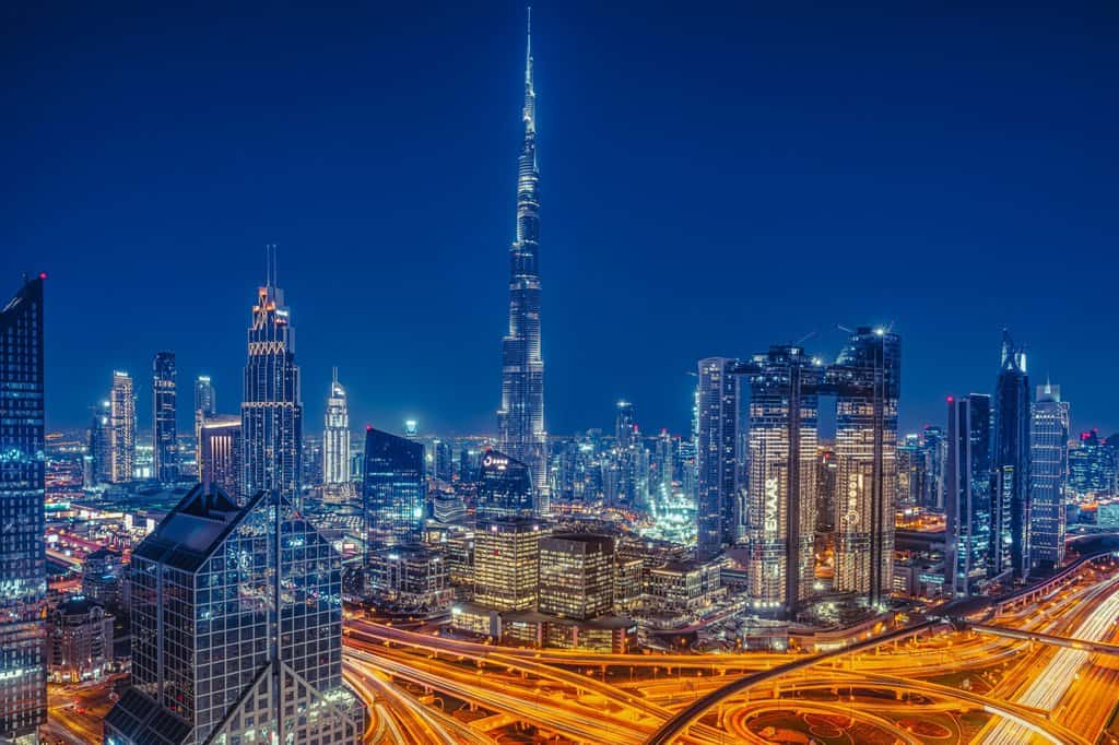 dubai at night with the burj khalifa tower in the background.