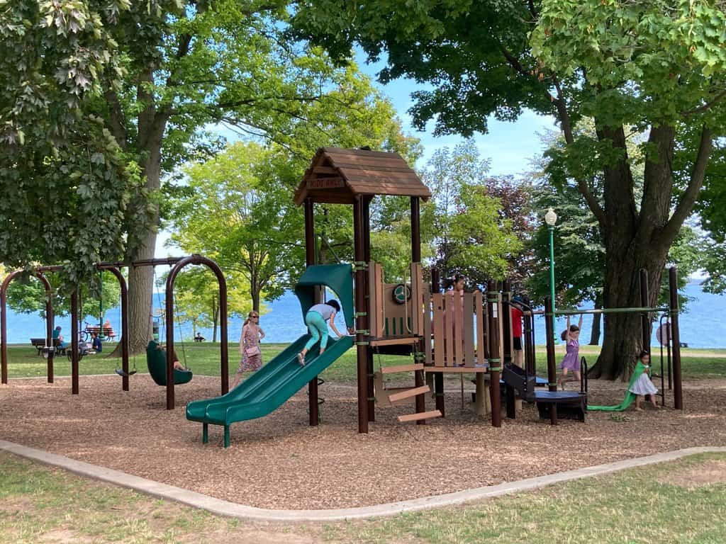 a children's playground with a slide and swings.