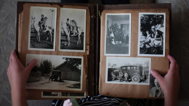 a woman is holding an old photo album.