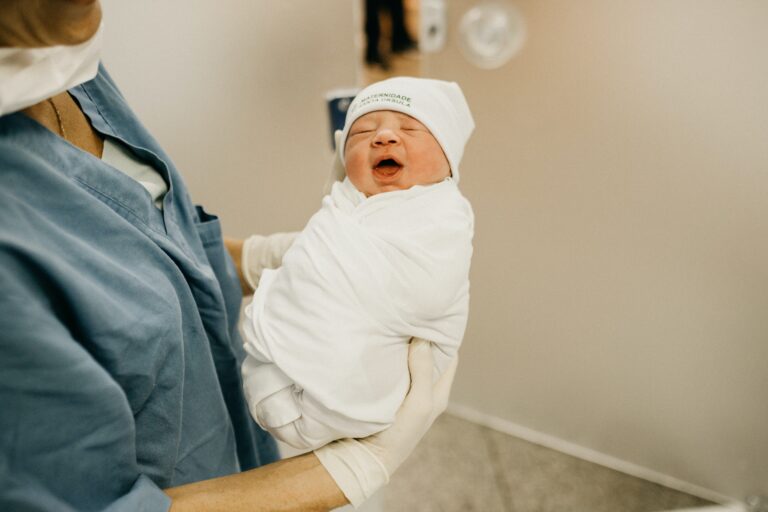 a nurse is holding a baby in a hospital.