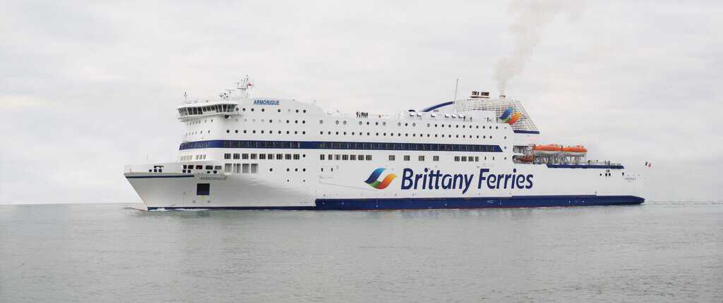 A large ferry with smoke coming out of it.