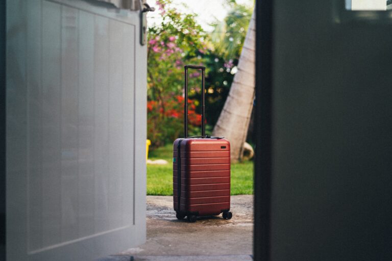 A red suitcase sitting in a doorway.