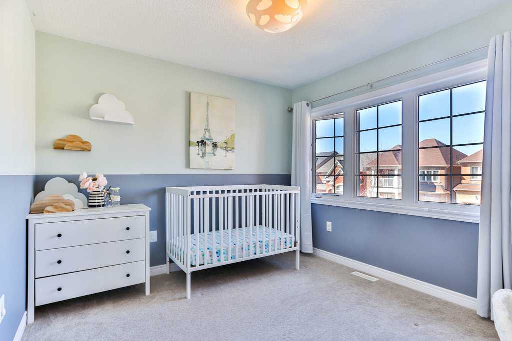 Creating a serene blue and white nursery room, perfect for a growing baby, with a cozy crib and spacious dresser.