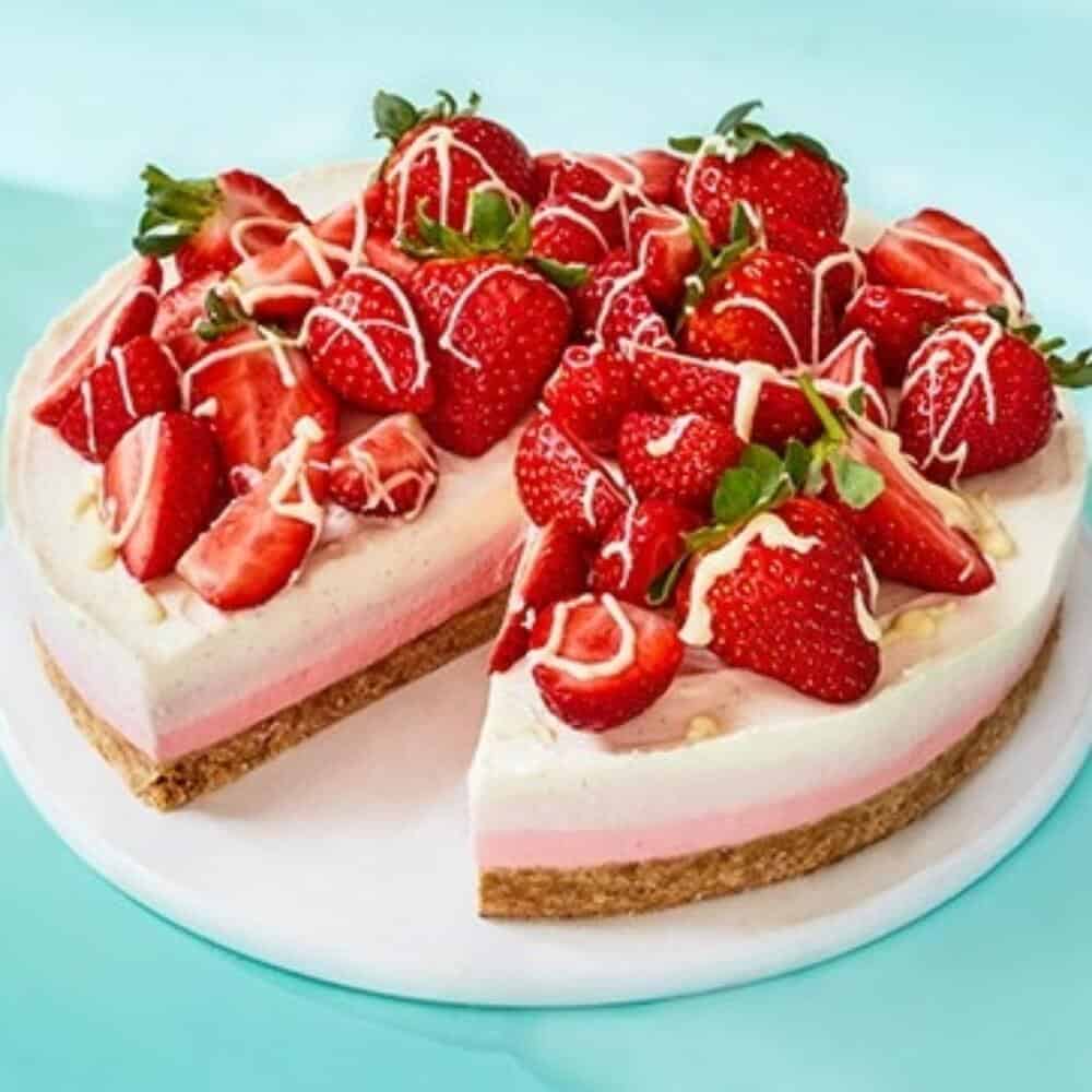 A popular strawberry cheesecake with a slice taken out, beautifully displayed on a plate.